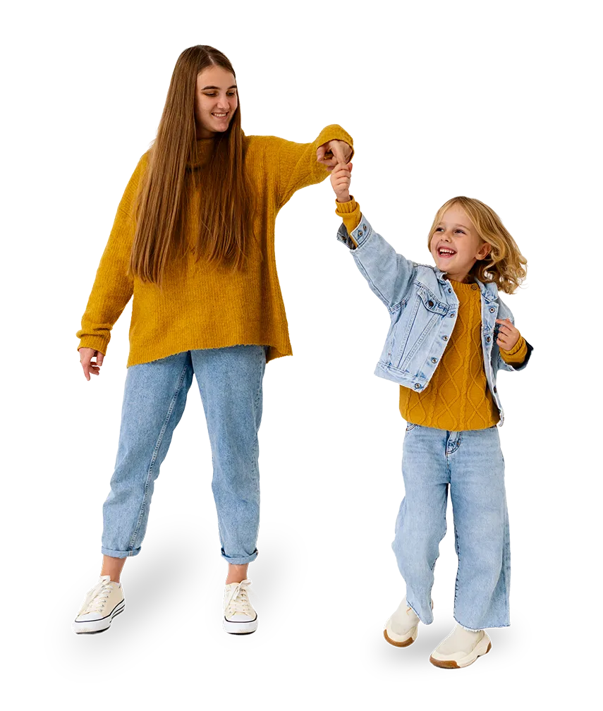 Älteres Mädchen hält lachend die Hand eines Kindes